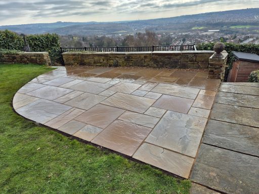 Patio area with large stone slabs, overlooking a picturesque landscape and hills.